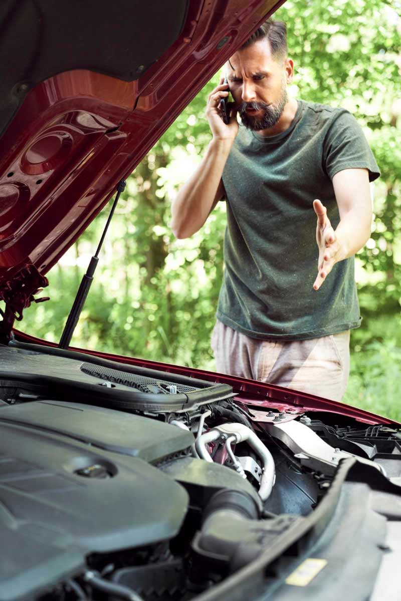 Junger Mann prüft Getriebeschaden bei Schrottauto Ankauf Hamburg